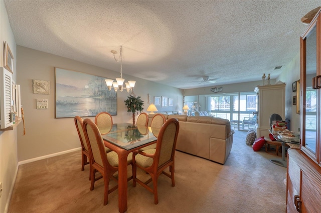 dining room featuring ceiling fan with notable chandelier, carpet floors, and a textured ceiling