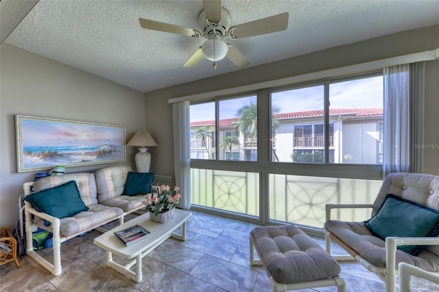 living room with a textured ceiling, vaulted ceiling, and ceiling fan