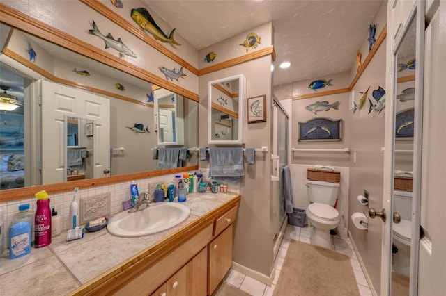 bathroom featuring vanity, tile patterned flooring, decorative backsplash, toilet, and walk in shower