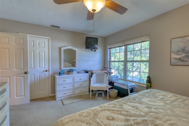 carpeted bedroom with ceiling fan, a closet, and a textured ceiling