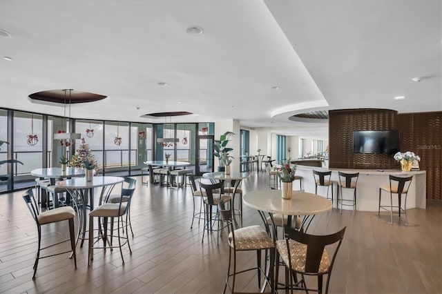 dining space with hardwood / wood-style flooring and a wall of windows