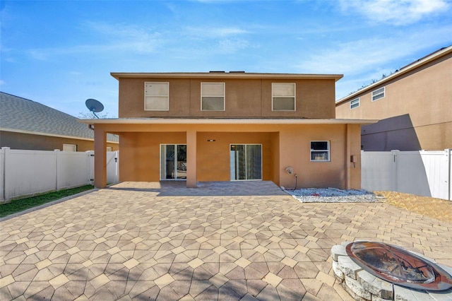 back of property featuring a patio area and a fire pit