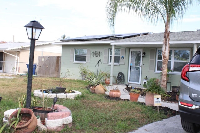 view of front of house with a front yard and solar panels