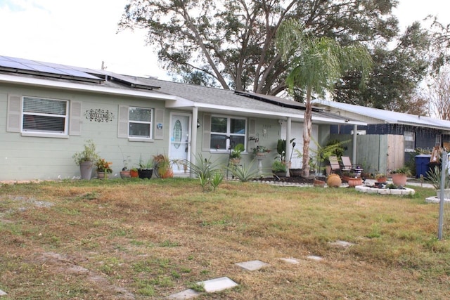 ranch-style home with solar panels and a front lawn