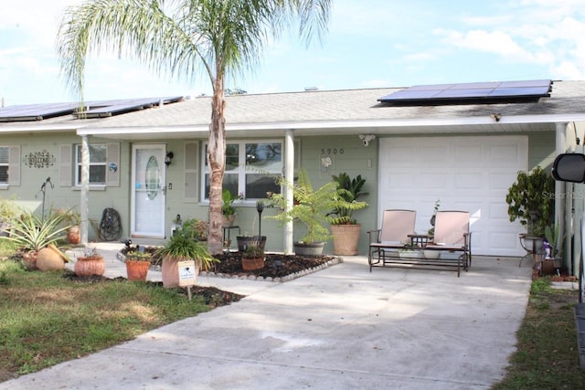 single story home featuring solar panels and a garage