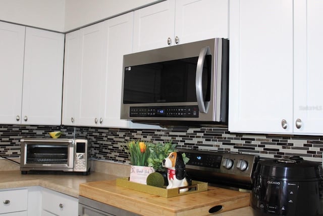 kitchen featuring decorative backsplash and white cabinets