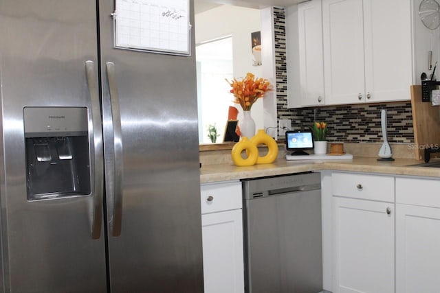 kitchen featuring white cabinets, appliances with stainless steel finishes, and decorative backsplash