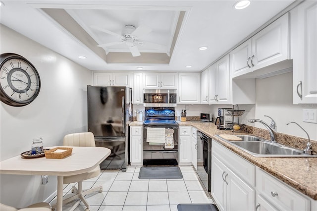 kitchen with black appliances, ornamental molding, sink, and a tray ceiling