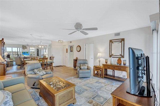 living room with ceiling fan with notable chandelier