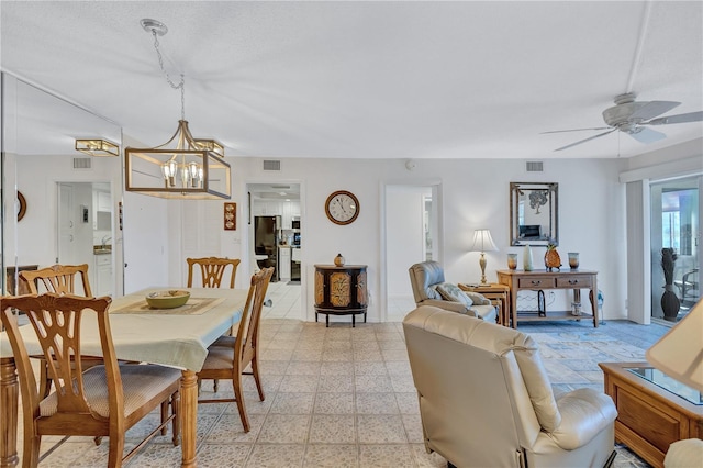 dining area with ceiling fan with notable chandelier