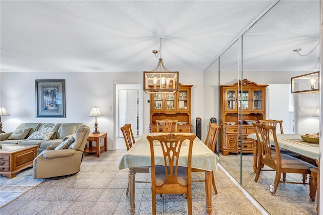 dining space featuring a chandelier and a textured ceiling