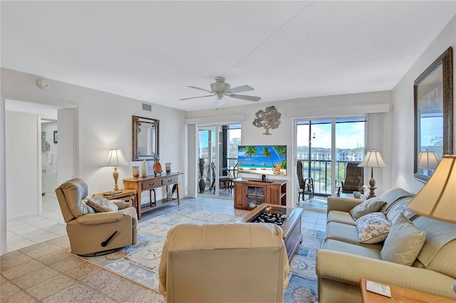 tiled living room with ceiling fan and a wealth of natural light