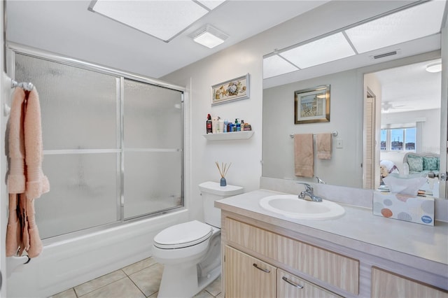 full bathroom featuring tile patterned flooring, vanity, combined bath / shower with glass door, and toilet