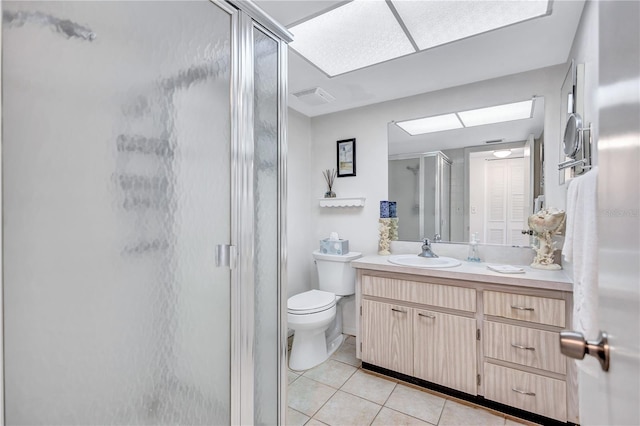 bathroom featuring tile patterned flooring, vanity, toilet, and a shower with door