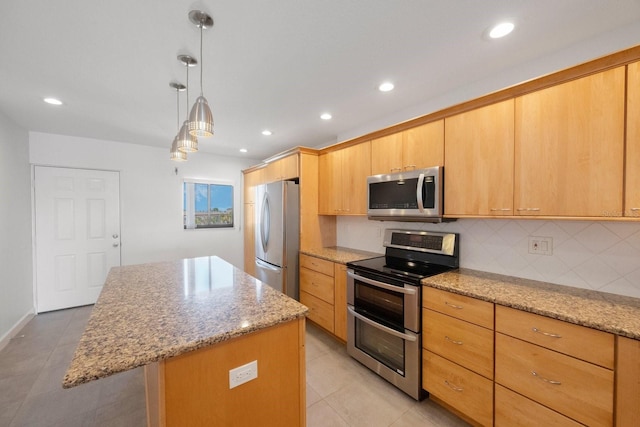 kitchen featuring light stone countertops, a center island, light brown cabinets, stainless steel appliances, and pendant lighting