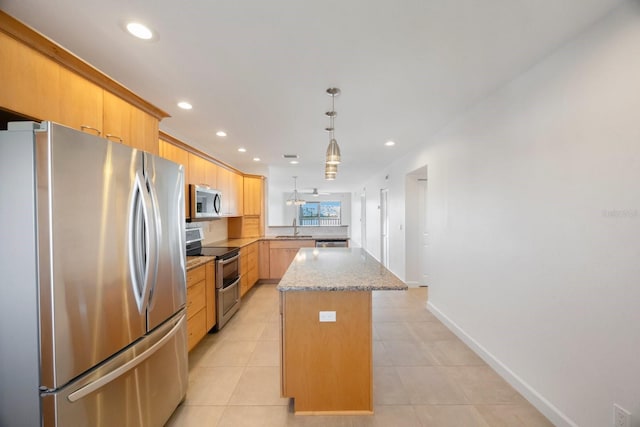 kitchen featuring pendant lighting, light tile patterned flooring, sink, appliances with stainless steel finishes, and a kitchen island