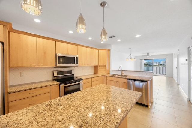 kitchen with kitchen peninsula, appliances with stainless steel finishes, ceiling fan, and light brown cabinetry