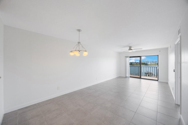 unfurnished room featuring light tile patterned flooring and ceiling fan with notable chandelier