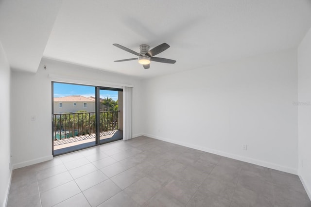 spare room with ceiling fan and light tile patterned floors