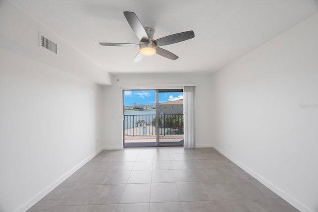 8701 Blind Pass Rd Unit 306B, St Pete Beach, FL 33706 - spare room featuring a ceiling fan, light tile patterned floors, and a water view