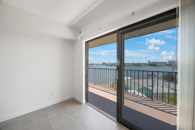 doorway to outside featuring a water view and light tile patterned floors