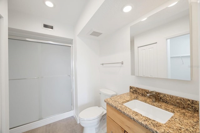 bathroom with vanity, toilet, and an enclosed shower