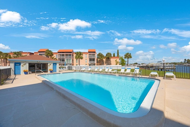 view of swimming pool with a patio area and a water view