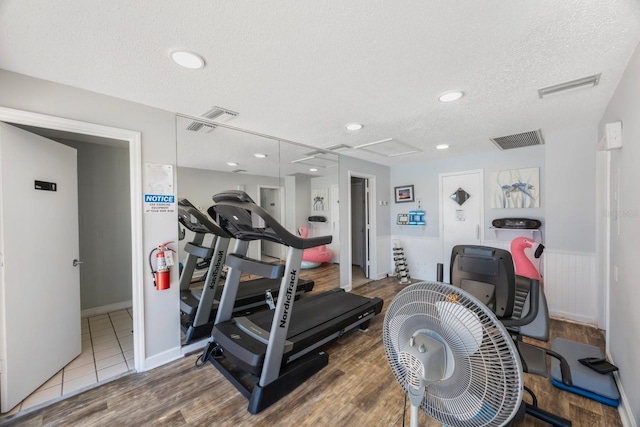 workout area featuring hardwood / wood-style floors and a textured ceiling