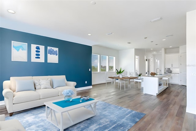 living room featuring hardwood / wood-style flooring and sink