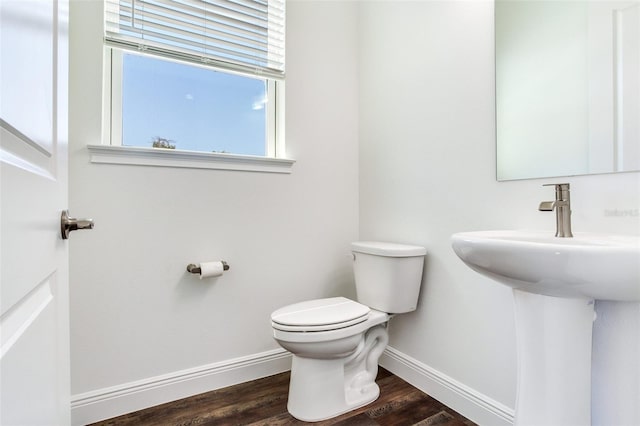 bathroom with hardwood / wood-style flooring, toilet, and sink