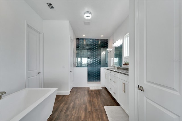 bathroom with plus walk in shower, vanity, and hardwood / wood-style flooring