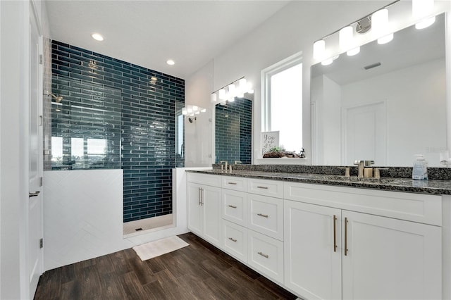 bathroom featuring tiled shower and vanity