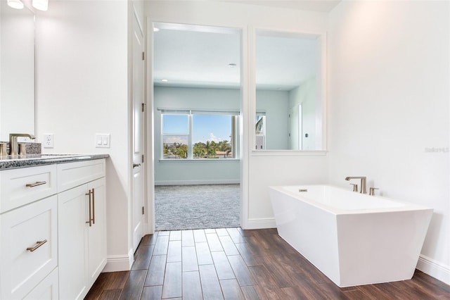 bathroom with a tub to relax in and vanity