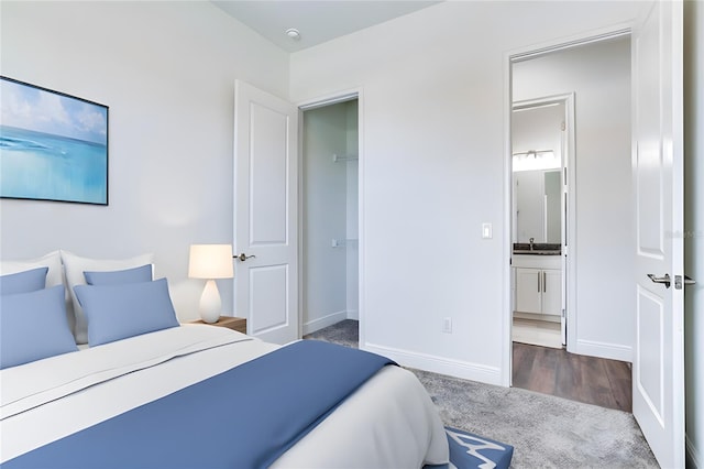 bedroom featuring dark colored carpet and ensuite bath