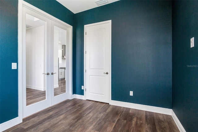 spare room with french doors and dark wood-type flooring