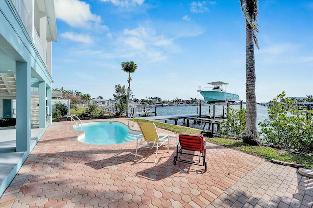 view of pool with a patio area, a dock, and a water view