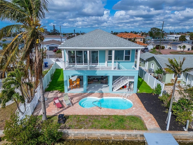 back of house with a fenced in pool and a patio