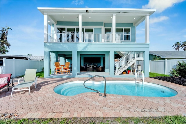 rear view of house with a fenced in pool and a patio area