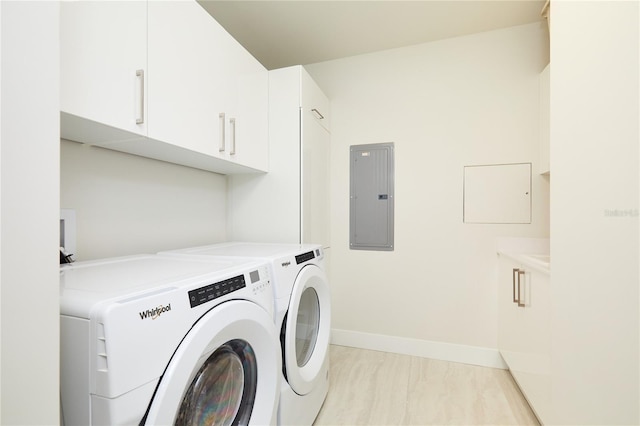 clothes washing area with electric panel, cabinets, light tile patterned floors, and washer and dryer