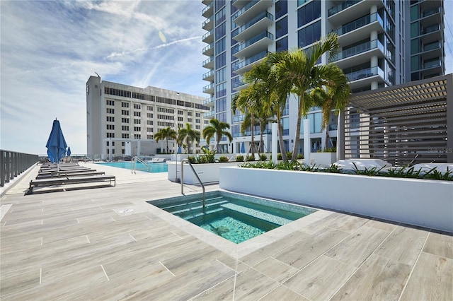 view of swimming pool with a patio area and a hot tub