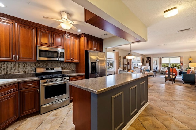 kitchen with ceiling fan, stainless steel appliances, backsplash, light tile patterned flooring, and a center island