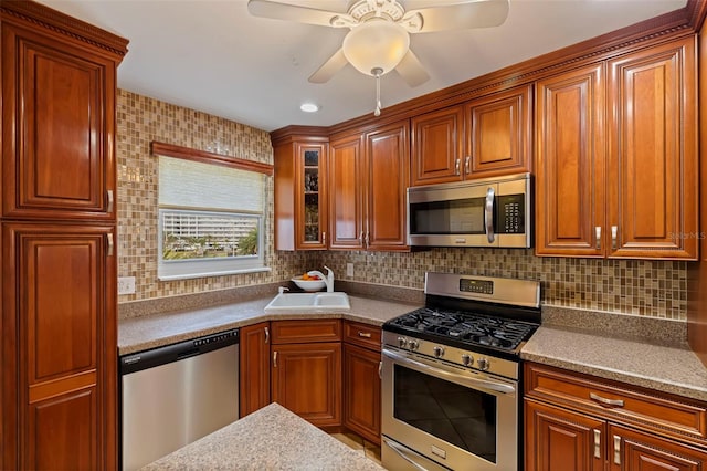 kitchen featuring decorative backsplash, sink, appliances with stainless steel finishes, and ceiling fan