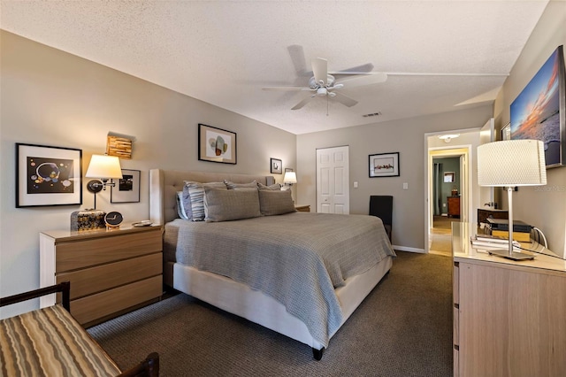 carpeted bedroom featuring a textured ceiling and ceiling fan