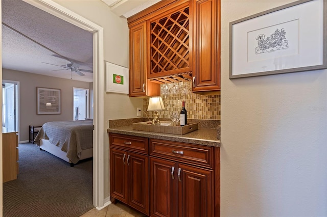 bar with light carpet, a textured ceiling, decorative backsplash, and ceiling fan