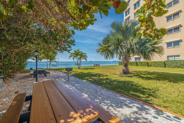 surrounding community featuring a water view and a lawn