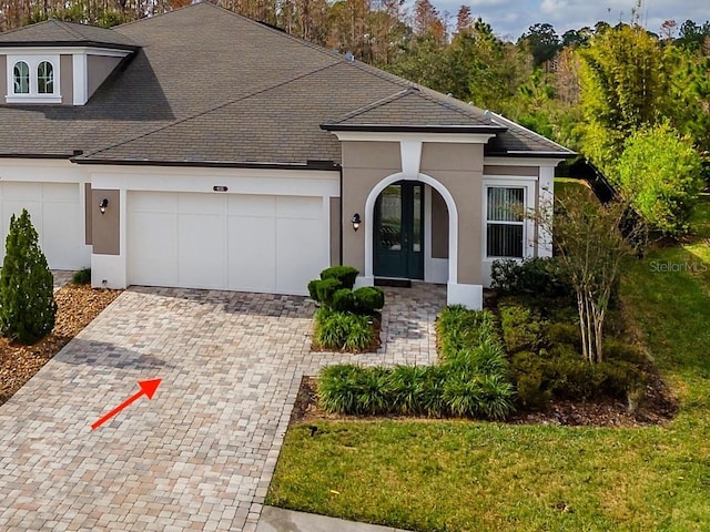 view of front of property with french doors, a garage, and a front lawn