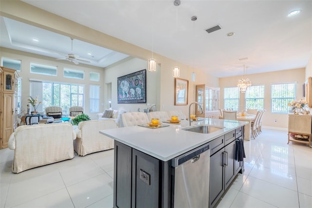 kitchen featuring ceiling fan with notable chandelier, a kitchen island with sink, sink, pendant lighting, and dishwasher