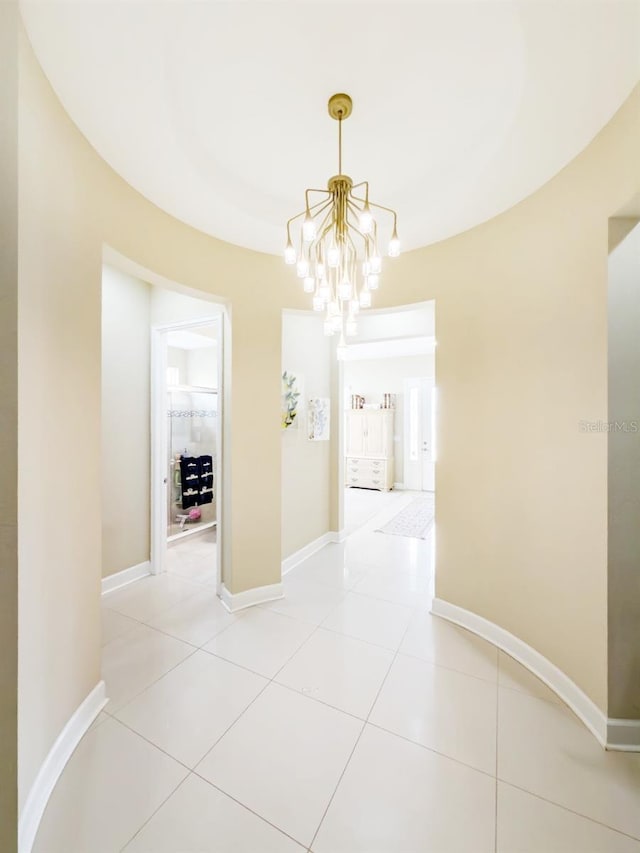 hallway with light tile patterned flooring and an inviting chandelier