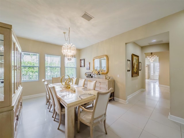 tiled dining area featuring a chandelier