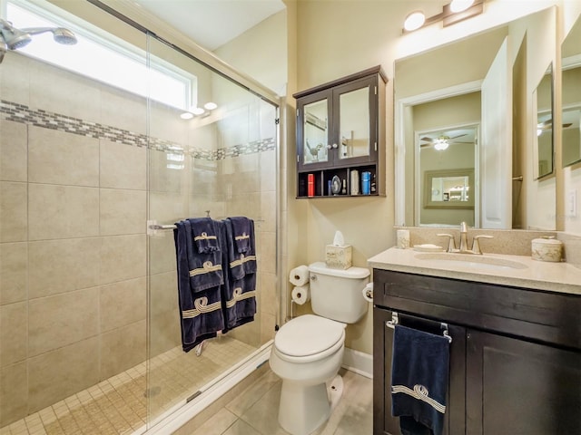 bathroom with vanity, a shower with door, tile patterned floors, ceiling fan, and toilet